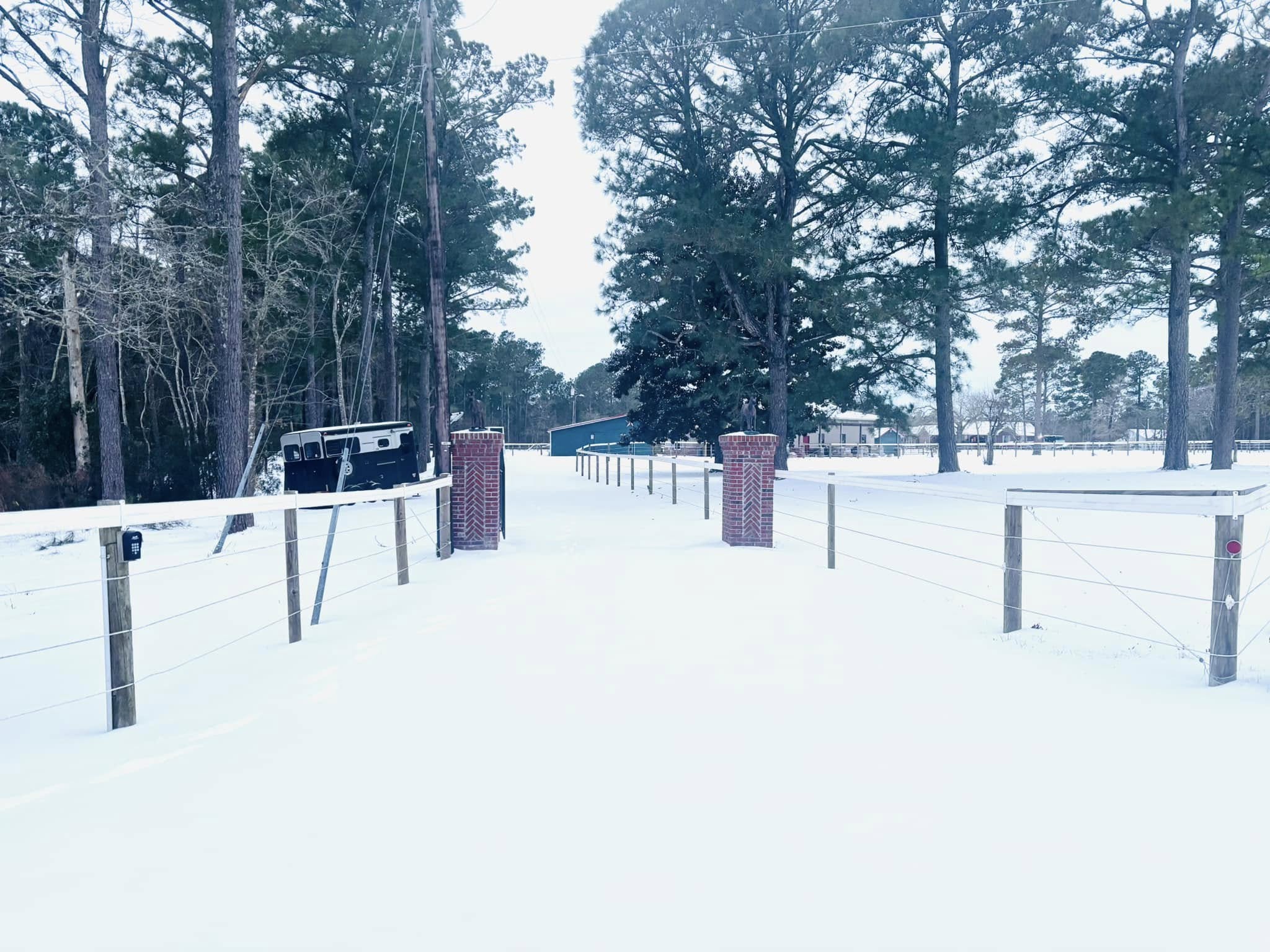 Snowy driveway with pillars